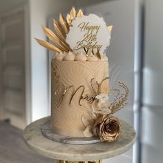 a birthday cake decorated with gold and white decorations