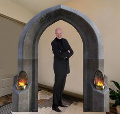 a man standing in front of an arch with fire coming out of it and his hands on his hips