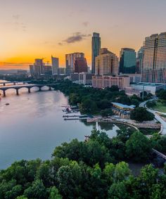 an aerial view of the city and river at sunset