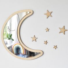 the moon and stars are hanging on the wall above the mirror, which is decorated with wood