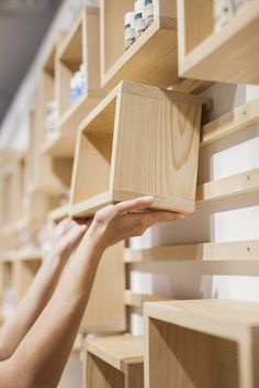 a person is reaching for some wooden shelves