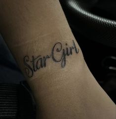 a person with a tattoo on their arm that says star girl in cursive writing