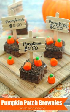 pumpkin patch brownies on a cutting board with wooden signs and mini pumpkins in the background