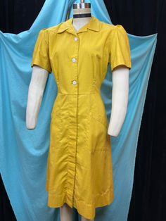 "1940s W:32 Coronet vintage uniform dress sanforized cotton pockets mustard yellow short sleeve button up collared V neck button A-line  Great 40s uniform dress from Coronet, Los Angeles. Aline silhouette of paneled construction with placket. Two side pockets. Fitted bodice with white buttons, opening all the way. Dense cotton weave in amazing shade of vintage mustard yellow. Puffed sleeves, collared V neckline.  Photographed on fitting form size 2, check measurements, vintage size labeled 36. M Vintage Workwear Dress With Button Closure, Yellow Button-up Cotton Dress, Vintage Cotton Workwear Dresses, Vintage Dress With Button Closure For Work, Vintage Cotton Dresses For Work, Yellow Cotton Button-up Dress, Solid Color Vintage Cotton Dress, Vintage Yellow Short Sleeve Dress, Vintage Short Sleeve Workwear Dress