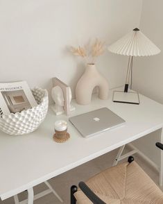 a white desk with a laptop, lamp and other items on top of the table