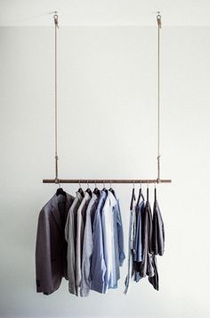 several shirts hanging on a clothes rack in a room