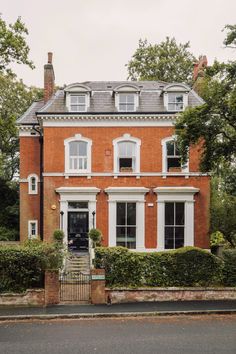 a large red brick house with white trim