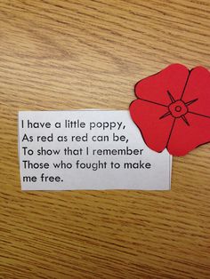 a piece of paper with a poem on it sitting on top of a wooden table