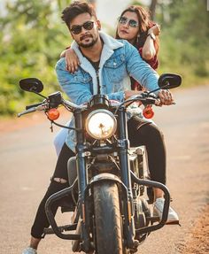 a man and woman riding on the back of a motorcycle