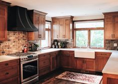 a kitchen with wooden cabinets and white counter tops, wood flooring and an oven