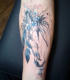 a tattoo with a horse and flowers on it