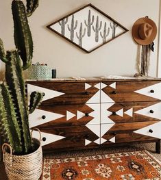 a large cactus sitting on top of a wooden dresser next to a mirror and rug