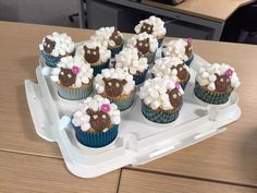 cupcakes with white and chocolate frosting in the shape of sheep