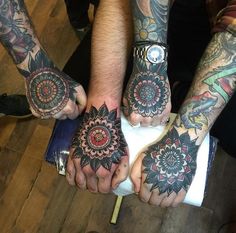 three people with tattoos holding their hands together