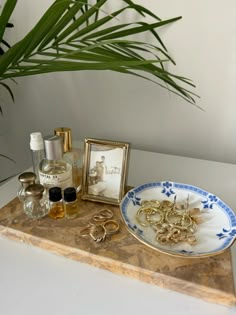 an assortment of personal items displayed on a marble tray with palm tree in the background