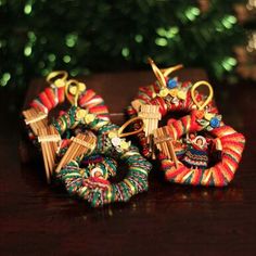 three colorful hair clips sitting on top of a wooden table next to a christmas tree