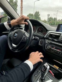 a man is driving his bmw car on the road