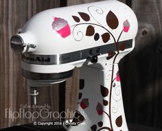 a white mixer with brown and pink designs on it