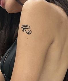 a woman's arm with an eye tattoo on the left side of her arm