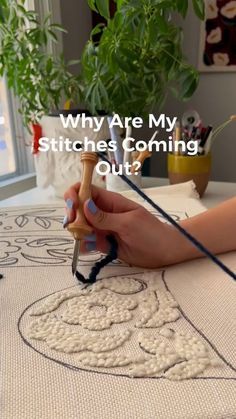 a woman is working on a piece of art with the words, why are my stitches coming out?