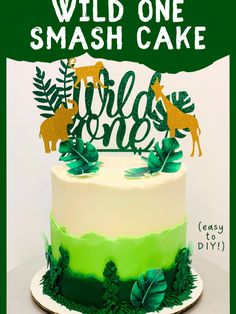 a green and white cake with the words wild one smash cake