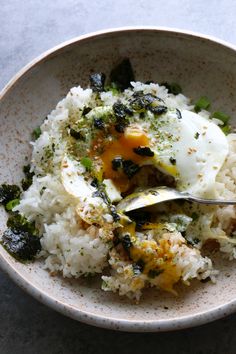 a white bowl filled with rice and an egg