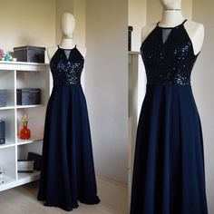 two dresses on mannequins, one in blue and the other in black