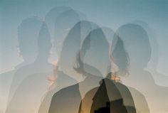 two people are standing in front of a window with the sun shining through them and their shadows