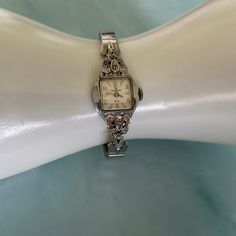 "Beautiful vintage Helbros ladies' silvertone mechanical cocktail watch in very good vintage condition. It is approximately 75 years old and running perfectly! There is some visible wear to the sides of the watch case (like smudge spots). The band is in near-perfect condition. The word \"Spiedel\" is printed all along the back of the watch band. I have carefully cleaned the watch and tested it. It has been running consistently and on time for over a month now each time I wind it.  It is a wind watch rather than a battery, so you do need to wind it every time you wear it. It is 17 jewels and running like a little machine! Measurements: 7 inches around and stretchable to at least another 2 inches. The watch case is 3/4 of an inch wide. Perfect gift for lovers of old cocktail watches." German Beer Mug, Cocktail Watch, Cocktail Vintage, Sweet Earrings, Womens Cocktail Dresses, Dress Watch, Women Wrist Watch, Wrist Watches, Watch Case