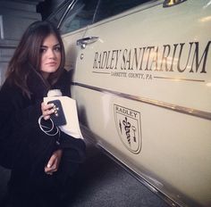 a woman leaning against the side of a white car