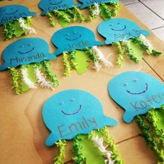 there are many blue and green items on the table with name tags attached to them