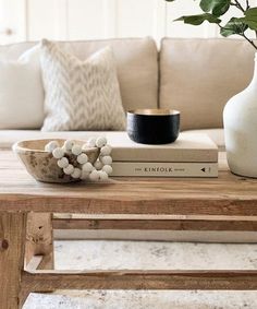 a living room with a couch, coffee table and vase on top of the book