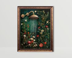 a painting with flowers and plants on the wall next to a framed object that has a light fixture hanging from it's side