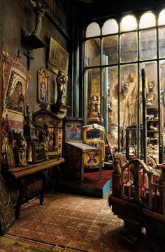 an old room with many antique items on display in the window sill and windows