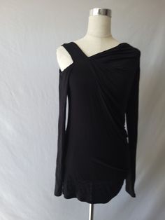 You will be " So Chic" and sexy in our shirring detail asymmetric long sleeve top. This top with hug you un all the right places and also feel comfortable with the soft,lightweight ,stretchy material. Featuring cut out right shoulder, asymmetric neckline, solid black color, long sleeves and hits you below the waist. Paired with our ''Roize'' jeans but can pair also with some distressed jeans. Rayon/Spandex Fit: True to size Made in U.S.A Machine wash cold Hang dry Stretch Top With Ruched Asymmetrical Neckline, Ruched Top With Stretch And Asymmetrical Neckline, Asymmetrical Neckline Top With Ruched Stretch, Asymmetrical Neckline Top With Ruched Detail, Fall Ruched Asymmetrical Top, Draped Tops For Fall Night Out, Draped Tops For Night Out In Fall, Black Draped Tops For Fall, Stretch Long Sleeve Blouse For Night Out