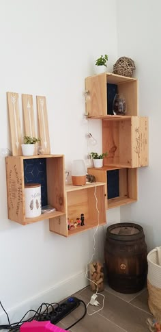 some wooden shelves with plants and other items in them on the wall next to a barrel