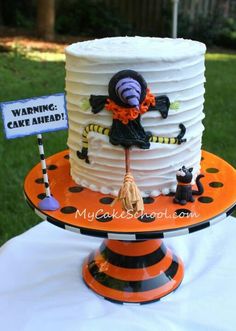 a halloween themed cake on an orange and black plate with a warning sign in the middle