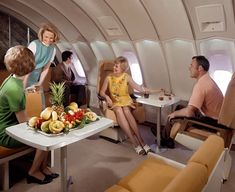 people sitting in an airplane with fruit on the table