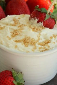 a close up of a dessert in a cup with strawberries on the rim and crumbs