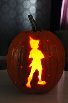 a carved pumpkin with the silhouette of a person on it