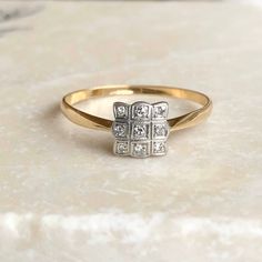 A vintage 18 carat gold diamond panel ring. This beautiful piece holds a gorgeous collection of nine diamonds in an exquisite setting. This piece is delicate and so pretty, a timeless and classic piece that oozes elegance! CONDITION: Wear consistent with age and use. Please see photos for more detail. SETTING SIZE: 6mm x 6mm SETTING HEIGHT: 2mm BAND WIDTH: 1mm RING SIZE: UK: R 1/2 | US: 8 3/4 WEIGHT: 1.7 grams (VZZ) Art Deco Gold Cluster Ring With Rose Cut Diamonds, Art Deco Gold Diamond Ring With Diamond Accents, Art Deco Gold Diamond Ring With Accents, Classic Gold Cluster Ring With Rose Cut Diamonds, Gold Art Deco Cluster Promise Ring, Classic Rose Cut Diamond Cluster Ring For Anniversary, Elegant Princess Cut Hallmarked Diamond Ring, Art Deco Gold Diamond Ring For Anniversary, Art Deco Gold Cluster Ring With Prong Setting