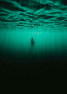 a person is swimming in the ocean at night