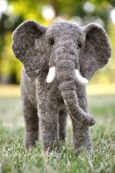 an elephant is standing in the grass with its trunk up and it's eyes closed