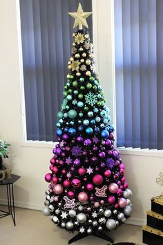 a decorated christmas tree in front of a window