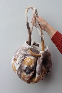 a hand holding a small purse with an animal print on it's side and the handle