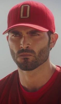 a man with a beard wearing a red baseball cap