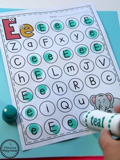 a hand holding a marker near a printable letter e worksheet for kids