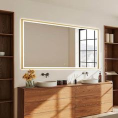 a bathroom with two sinks and a large mirror on the wall above it's cabinets