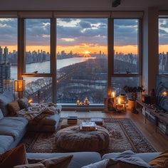 a living room filled with furniture and large windows overlooking the cityscape at sunset