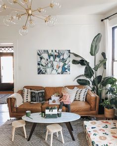 a living room filled with furniture and a chandelier hanging above the couches